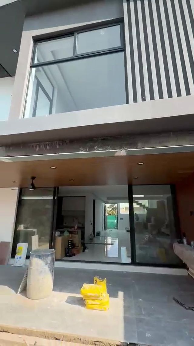 Ventanales de piso a techo con celosía vertical de madera